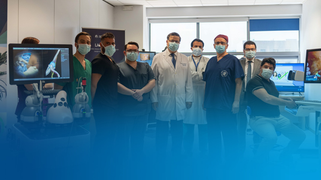 A group of medical professionals in scrubs poses with medical machinery