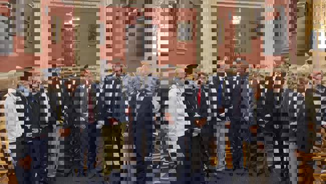 A group of people standing in a room, posing for a photo.