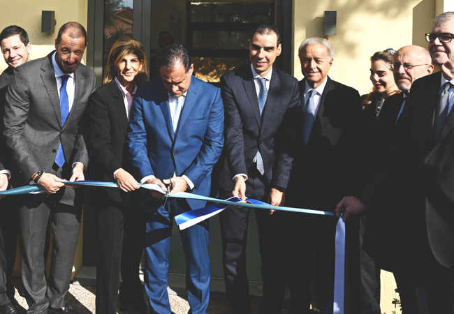 Κοπή κορδέλας από ομάδα ατόμων κατά τη διάρκεια εκδήλωσης εγκαινίων.