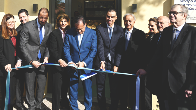 A group of individuals cutting a ribbon during an inauguration event.
